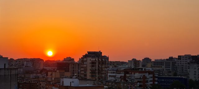 Tirane, perendimi i diellit sot. Horizonti qe flakeron tregon per nje dite tjeter te zjarrte qe na pret